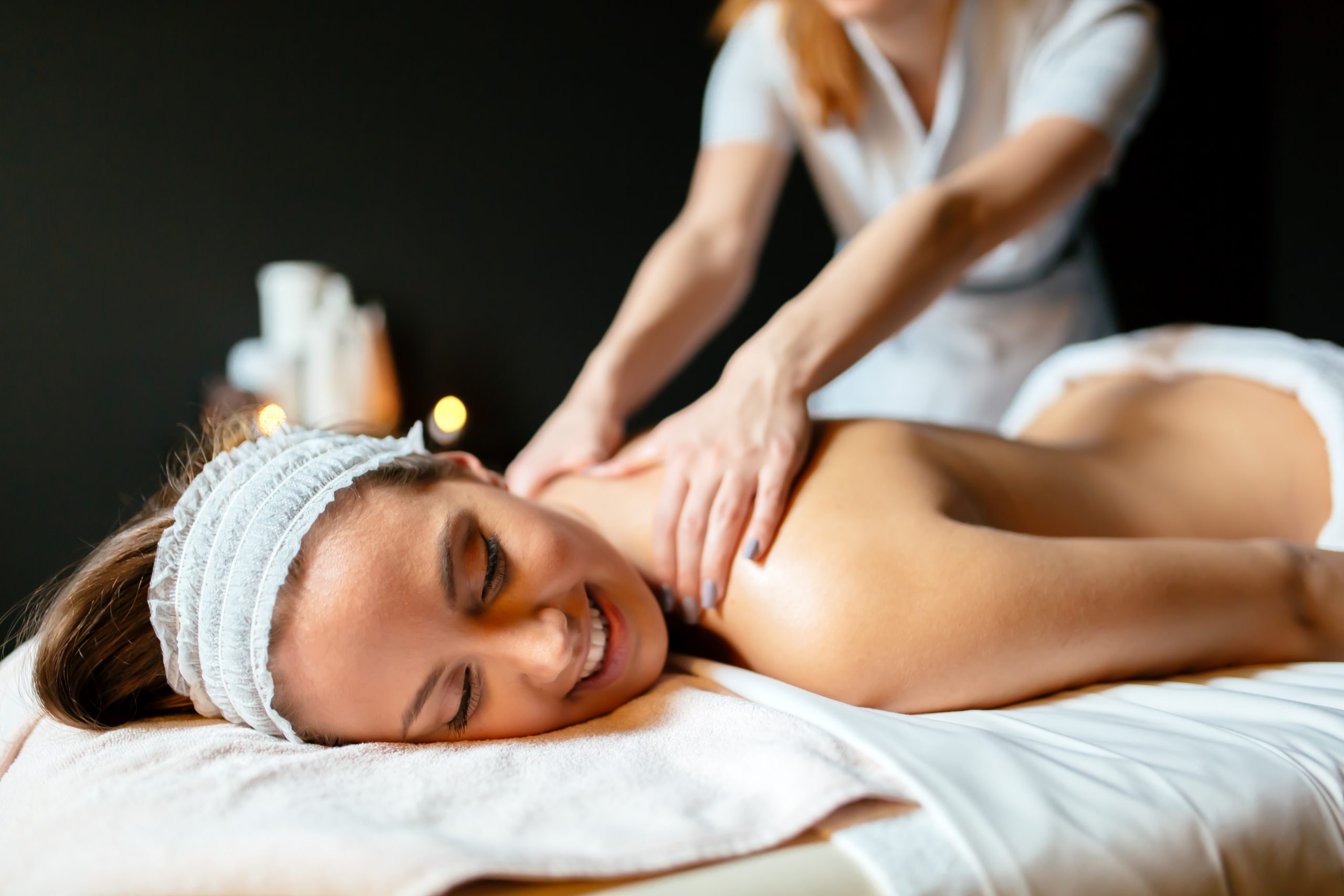 Massage therapist massaging woman in home massage for 1