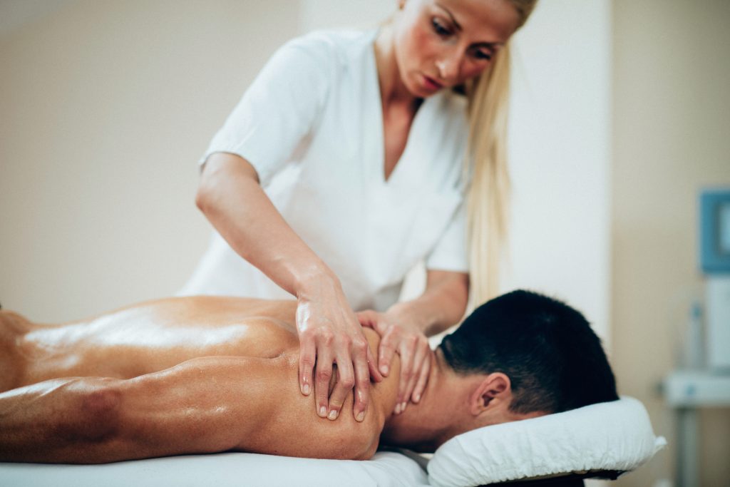 sports massage therapist doing shoulder massage 